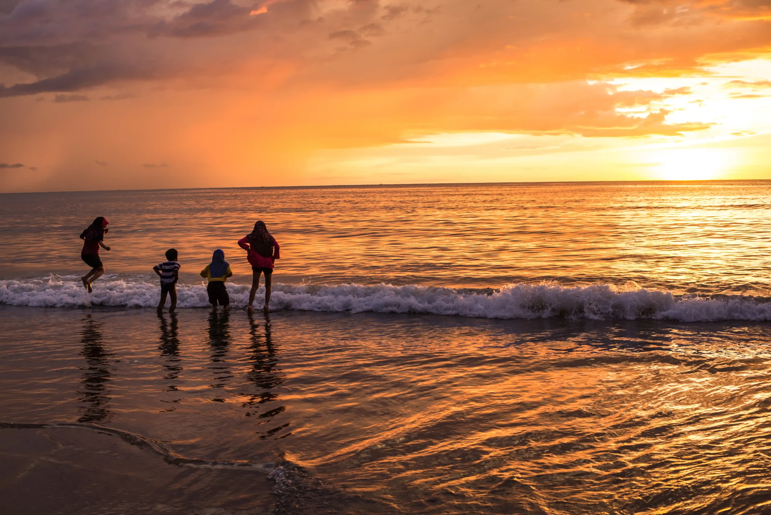 Familia en la playa con atardecer
